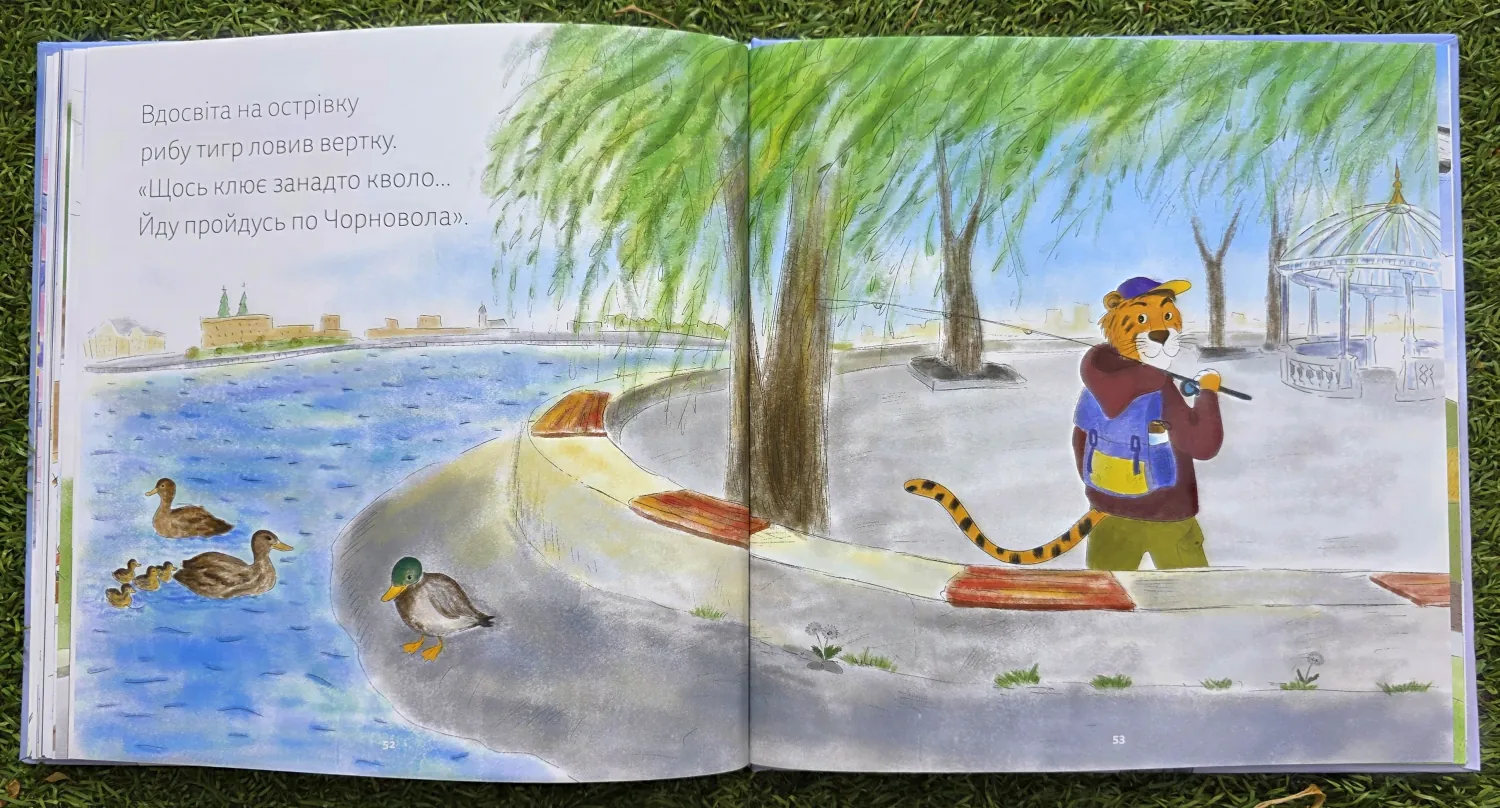 Розворот книжки: тигр ловить рибу на озері біля бульвару Чорновола